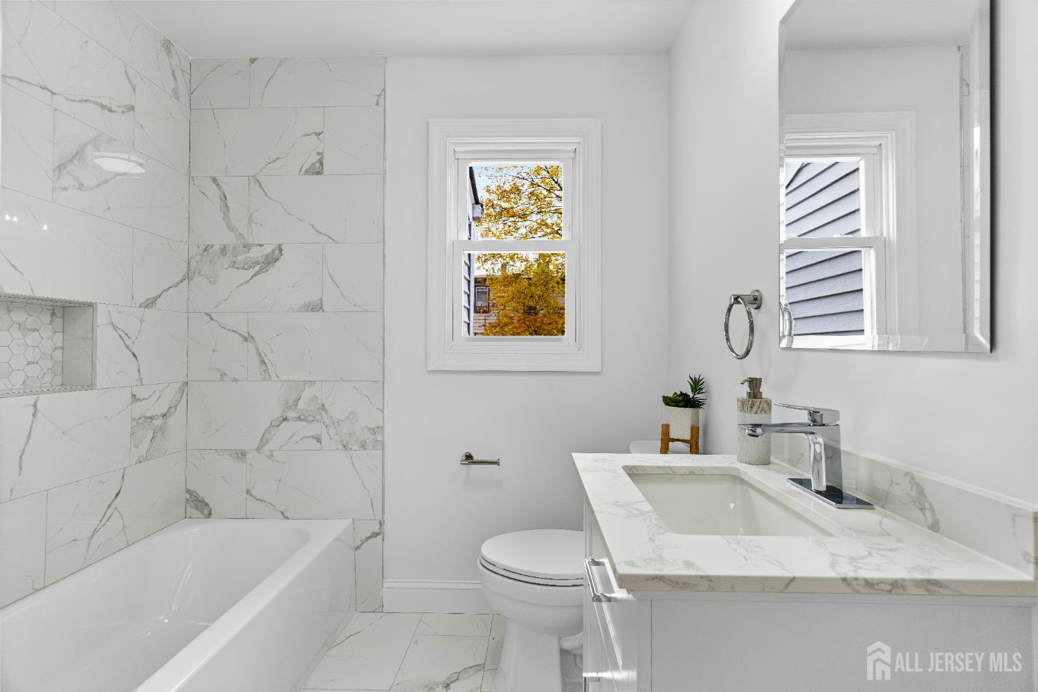 709 Front Street Dunellen, NJ 08812 - Photo 19 of 34 a bathroom with a granite countertop toilet sink and bathtub