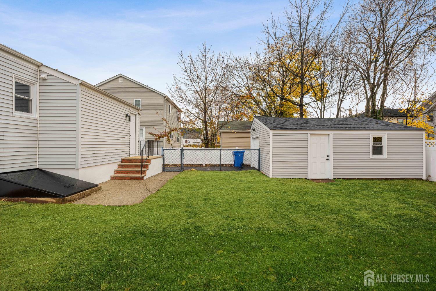 709 Front Street Dunellen, NJ 08812 - Photo 29 of 34 a view of a backyard with table and chairs and a barbeque