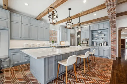 a kitchen with a dining table chairs cabinets and stainless steel appliances