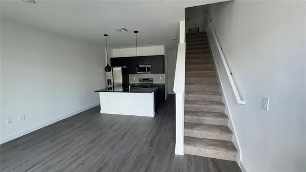a view of entryway and kitchen with wooden floor