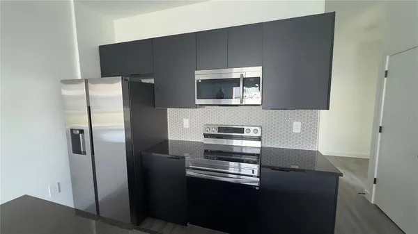 a kitchen with stainless steel appliances granite countertop a refrigerator a sink and a stove