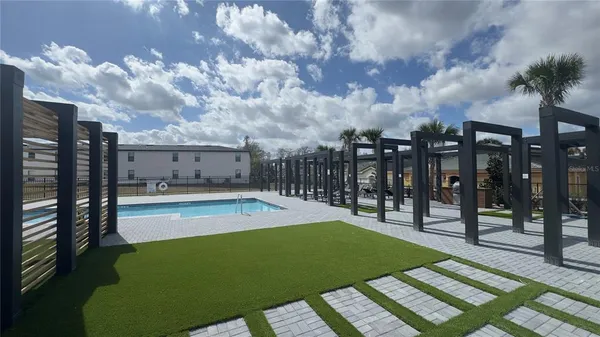 a view of swimming pool with outdoor seating and buildings in the background