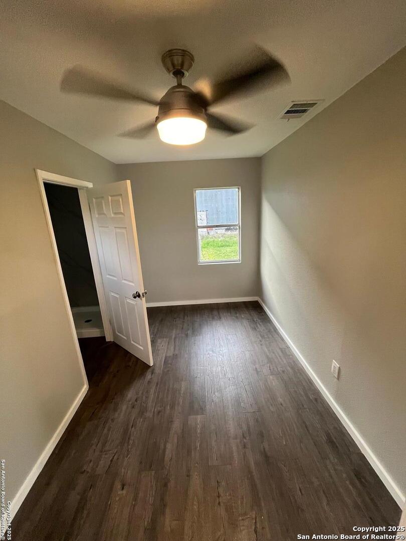 302 Ross Avenue Devine, TX 78016 - Photo 14 of 20 wooden floor in an empty room with a window
