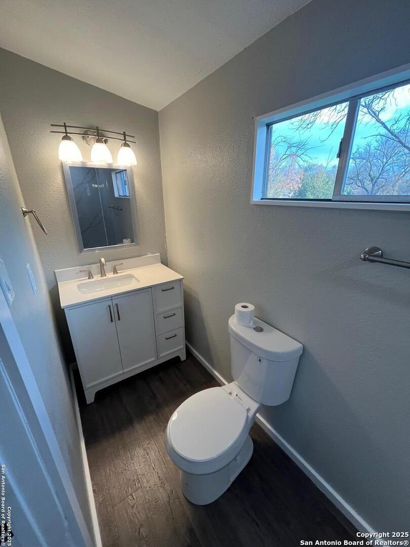 302 Ross Avenue Devine, TX 78016 - Photo 15 of 20 a bathroom with a toilet sink and mirror