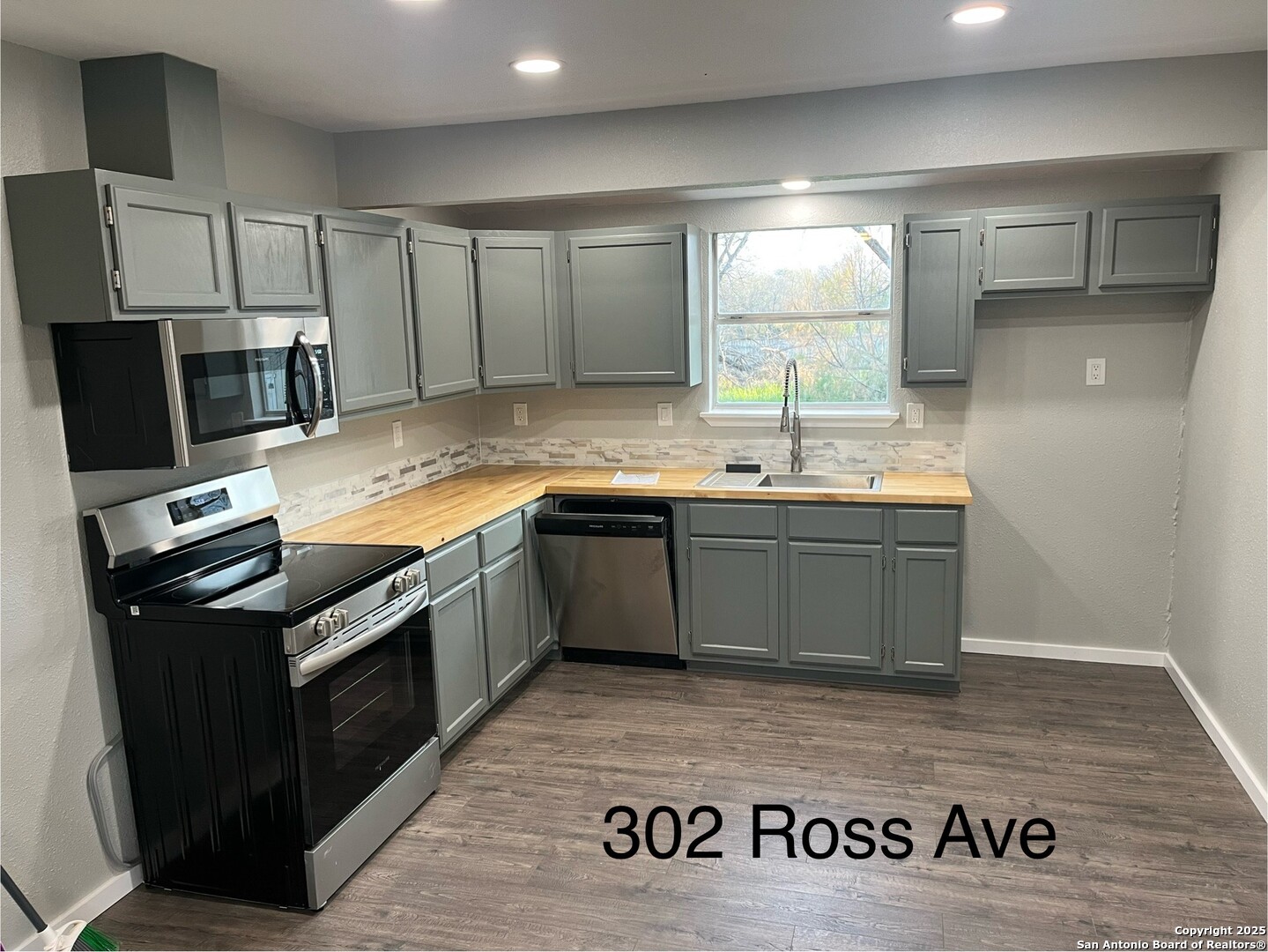 302 Ross Avenue Devine, TX 78016 - Photo 8 of 20 a kitchen with stainless steel appliances granite countertop a sink stove and refrigerator