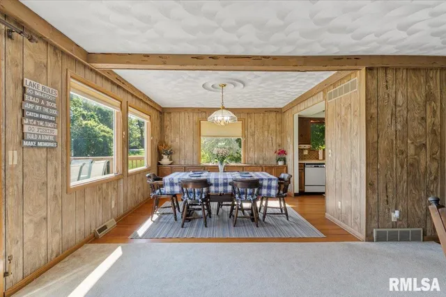 a dining room with furniture a chandelier and wooden floor