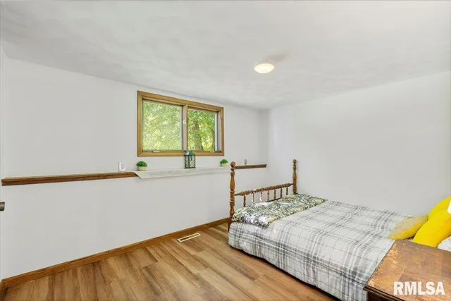 a bedroom with a bed and wooden floor