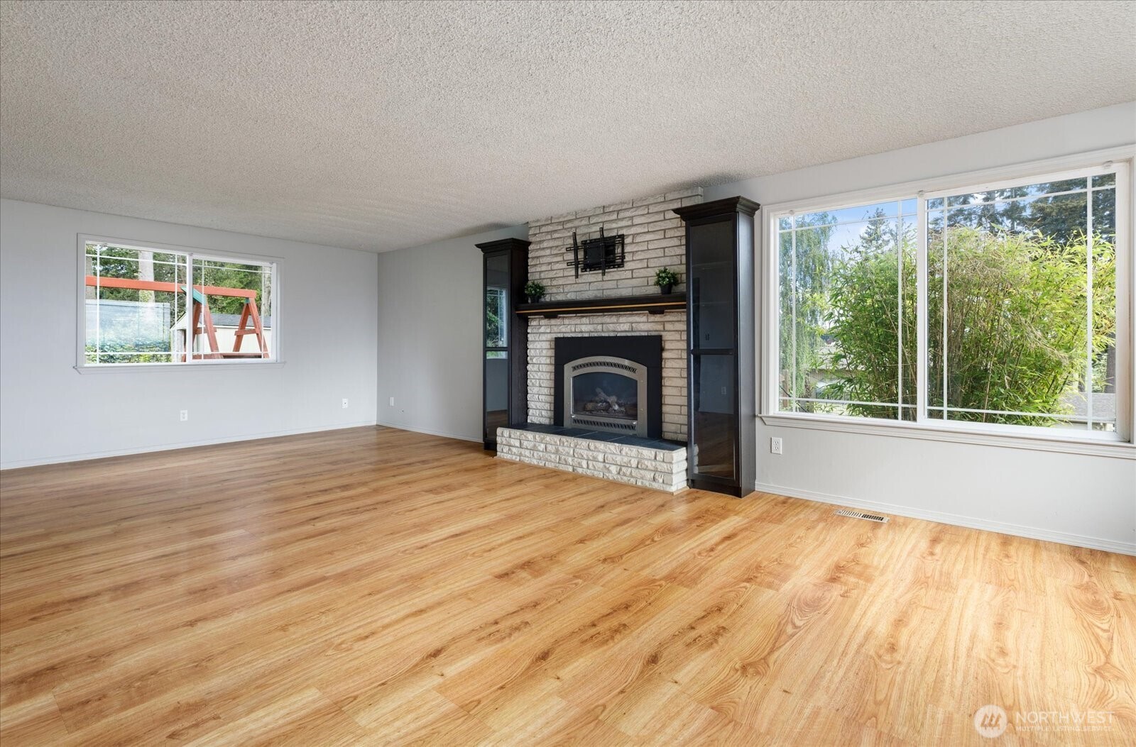960 Southwest Capital Street Oak Harbor, WA 98277 - Photo 11 of 40 a view of empty room with wooden floor and fireplace