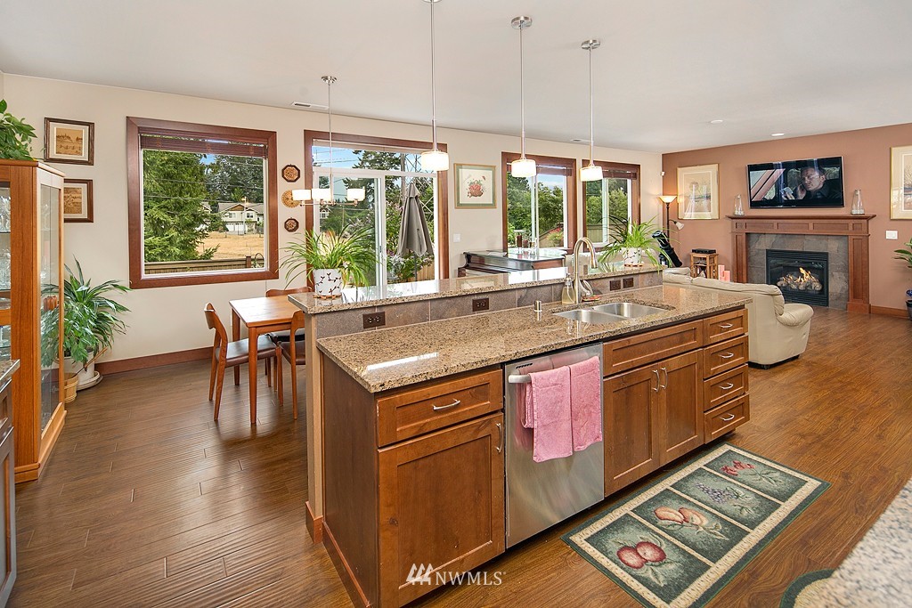 19809 3rd Avenue Southeast Bothell, WA 98012 - Photo 3 of 21 a open kitchen with stainless steel appliances granite countertop a stove a refrigerator a sink and a dining table with wooden floor
