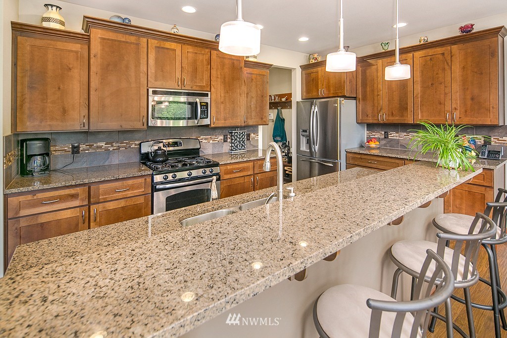 19809 3rd Avenue Southeast Bothell, WA 98012 - Photo 4 of 21 a kitchen with stainless steel appliances granite countertop a sink a stove and a refrigerator