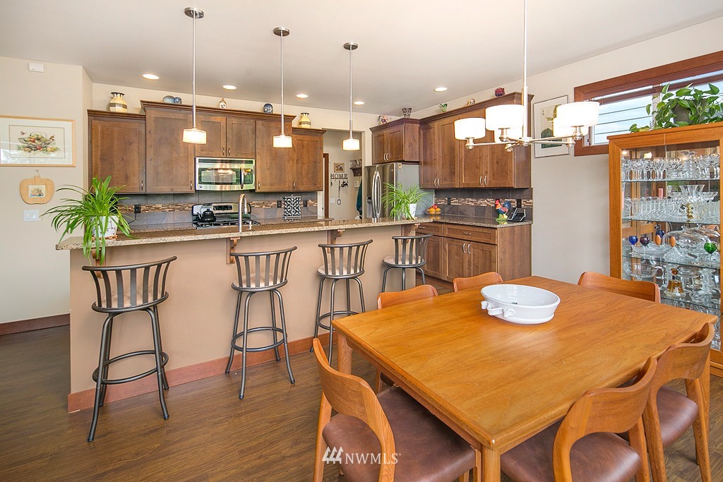 19809 3rd Avenue Southeast Bothell, WA 98012 - Photo 6 of 21 a kitchen with stainless steel appliances kitchen island granite countertop a dining table and chairs in it