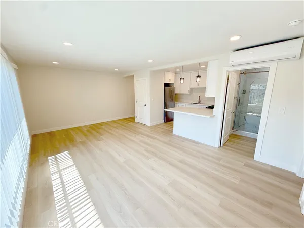 a view of a kitchen with furniture and wooden floor