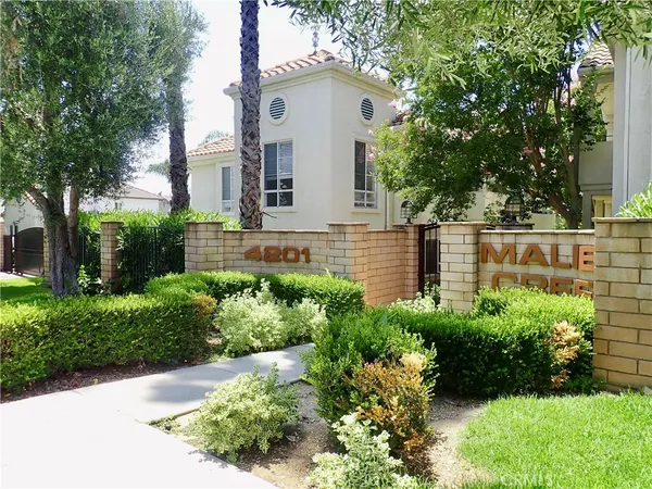 front view of a house with a yard and potted plants