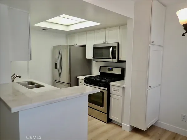 a kitchen with stainless steel appliances a stove microwave and refrigerator