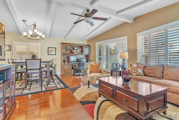 a dining room with furniture a chandelier and wooden floor