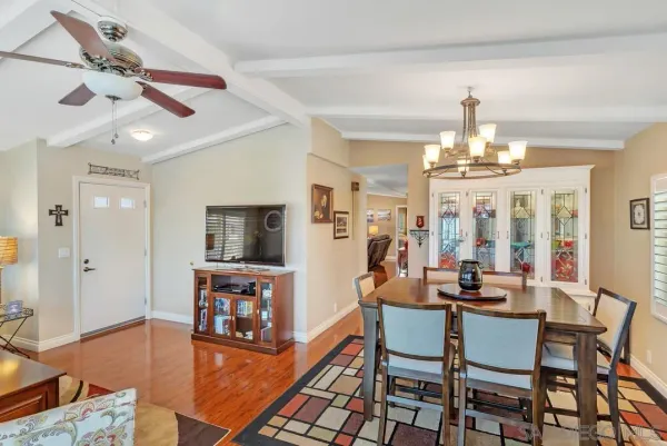 a kitchen with stainless steel appliances granite countertop a refrigerator a stove top oven and a dining table with wooden floor