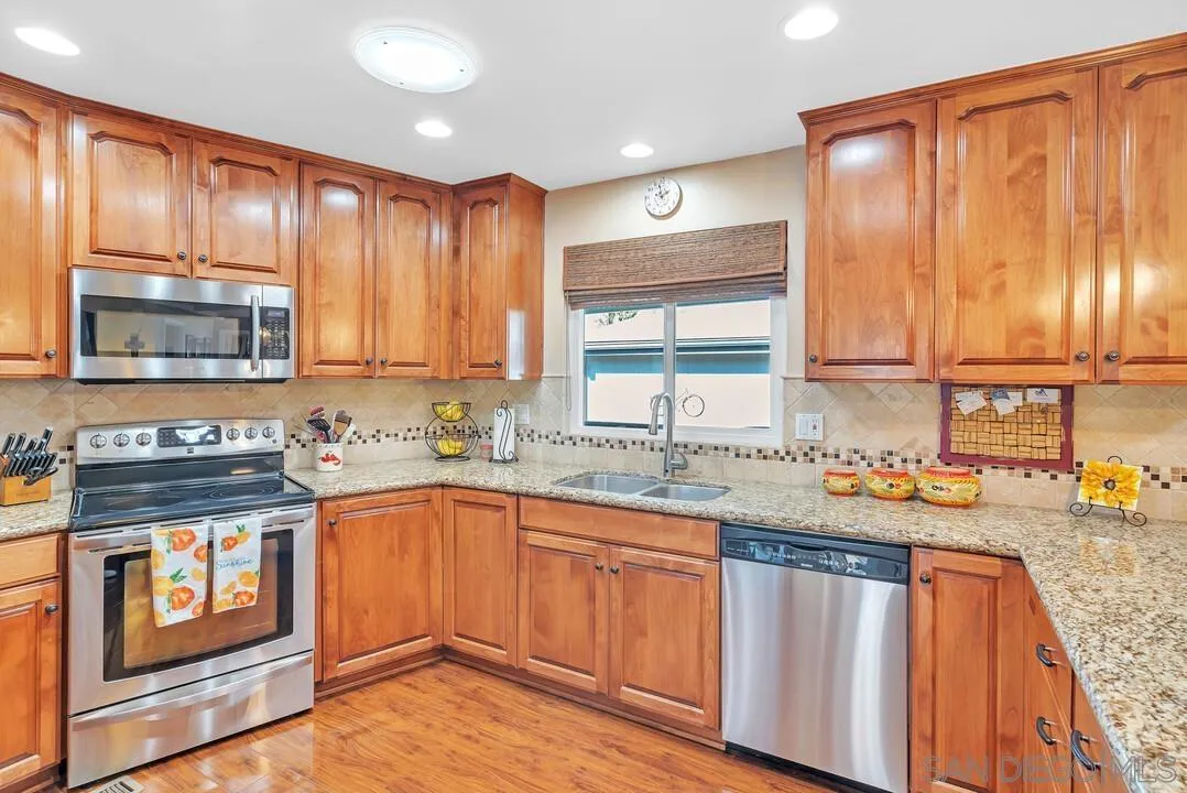 18218 Paradise Mountain Road, Unit 203 Valley Center, CA 92082 - Photo 23 of 68 a kitchen with stainless steel appliances granite countertop wooden cabinets a sink and a stove
