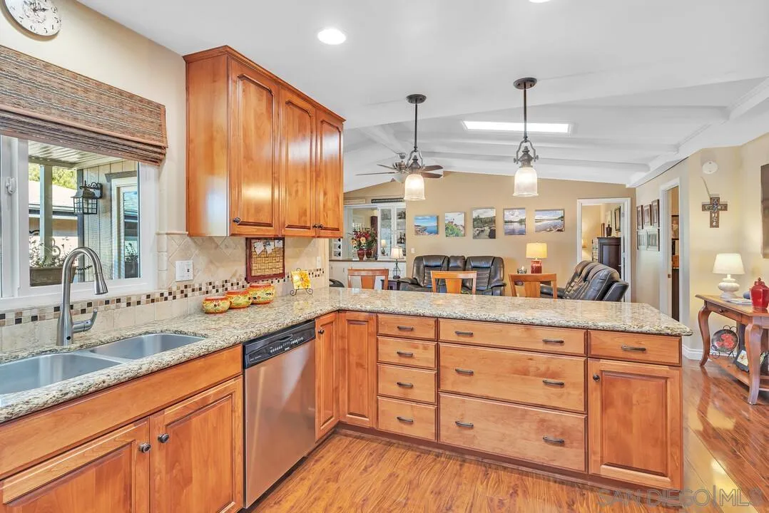 18218 Paradise Mountain Road, Unit 203 Valley Center, CA 92082 - Photo 25 of 68 a kitchen with stainless steel appliances kitchen island granite countertop a sink and cabinets