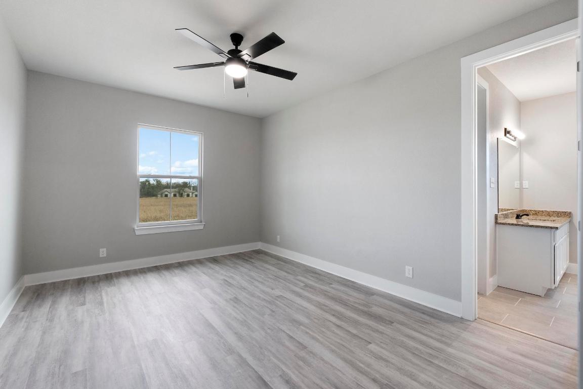 16544 Fm 112 Thrall, TX 76578 - Photo 20 of 28 an empty room with wooden floor and a ceiling fan