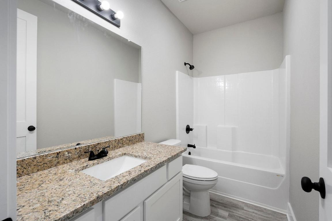 16544 Fm 112 Thrall, TX 76578 - Photo 22 of 28 a bathroom with a granite countertop sink toilet and shower