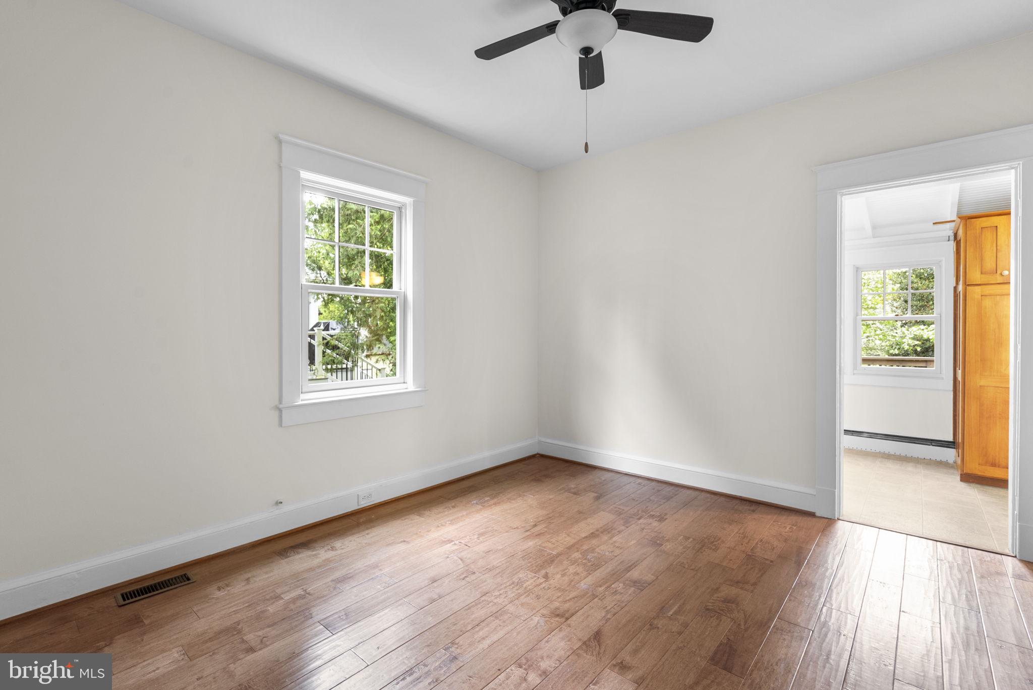 9120 Glenridge Road Silver Spring, MD 20910 - Photo 22 of 59 an empty room with wooden floor chandelier fan and windows