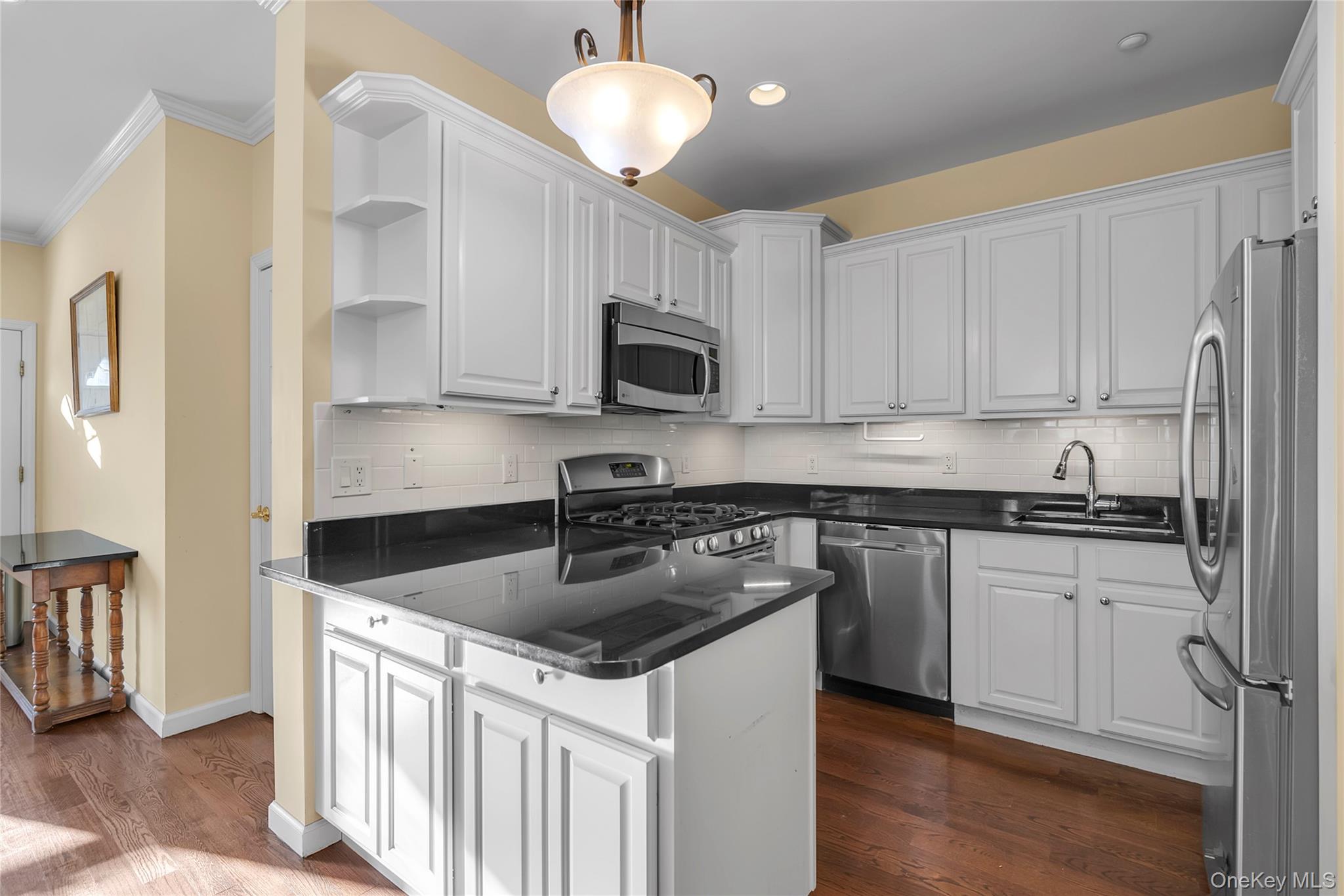 286 Spring Drive, Unit 286 East Meadow, NY 11554 - Photo 7 of 27 a kitchen with stainless steel appliances granite countertop a sink stove and microwave