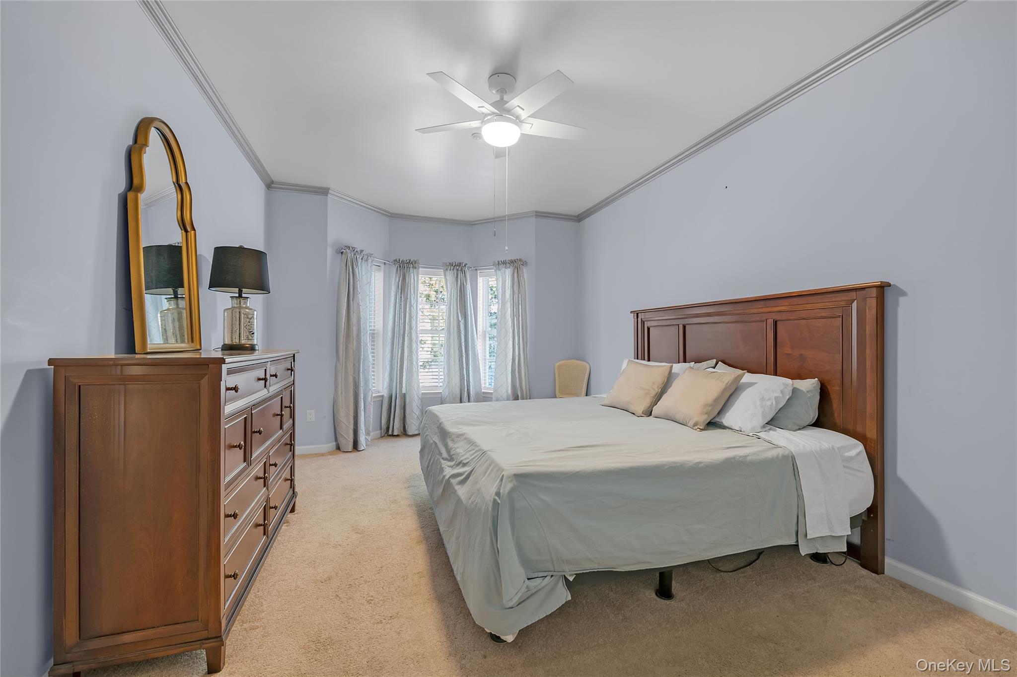 286 Spring Drive, Unit 286 East Meadow, NY 11554 - Photo 8 of 27 a spacious bedroom with a bed and a chandelier