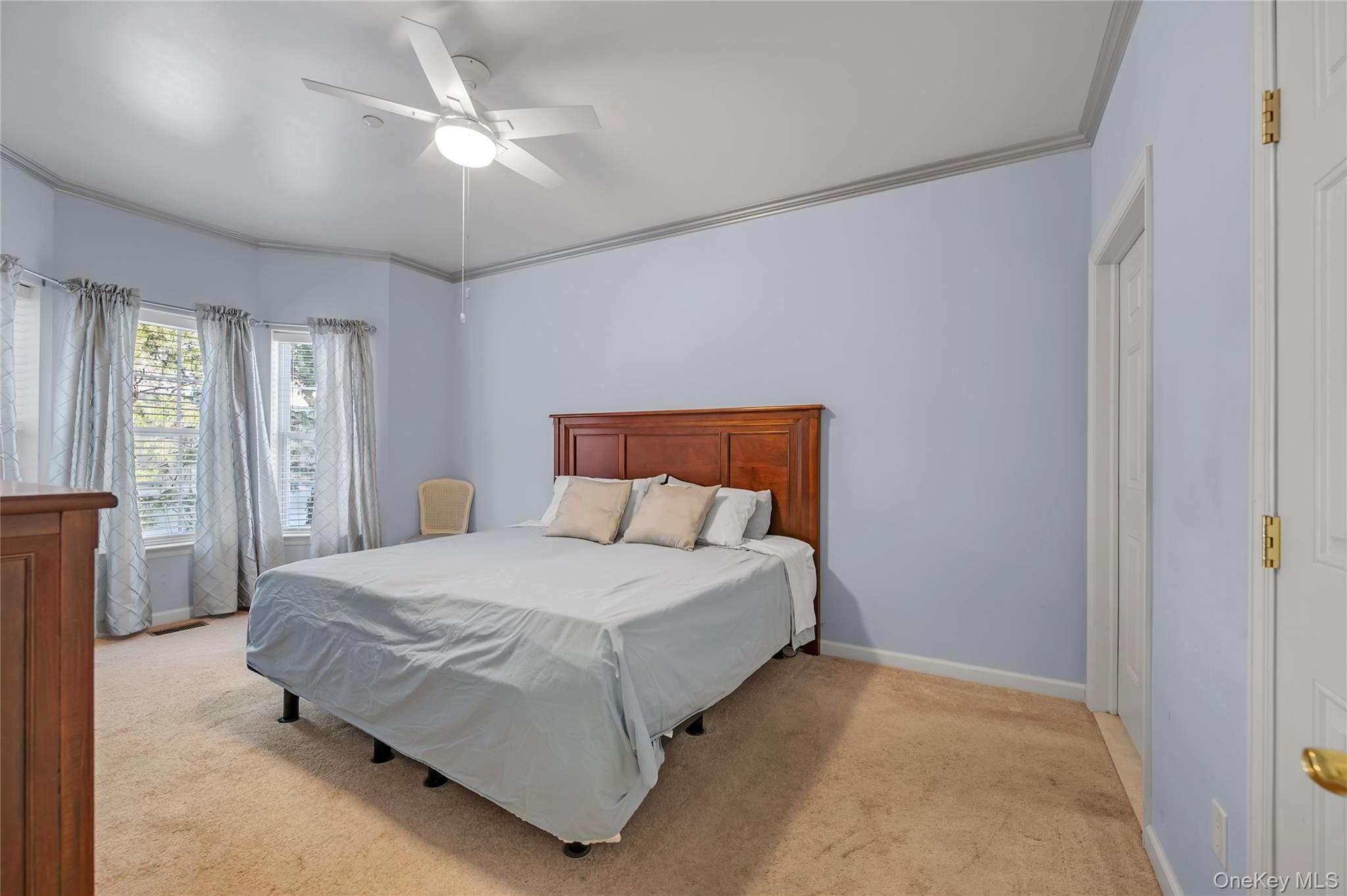 286 Spring Drive, Unit 286 East Meadow, NY 11554 - Photo 9 of 27 a bedroom with a bed and a chandelier