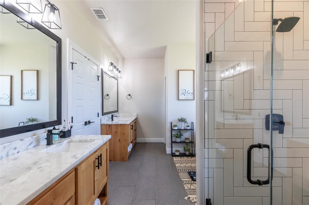 296 Mesquite Ridge Lane Lawn, TX 79530 - Photo 14 of 35 a bathroom with a granite countertop sink a mirror and shower