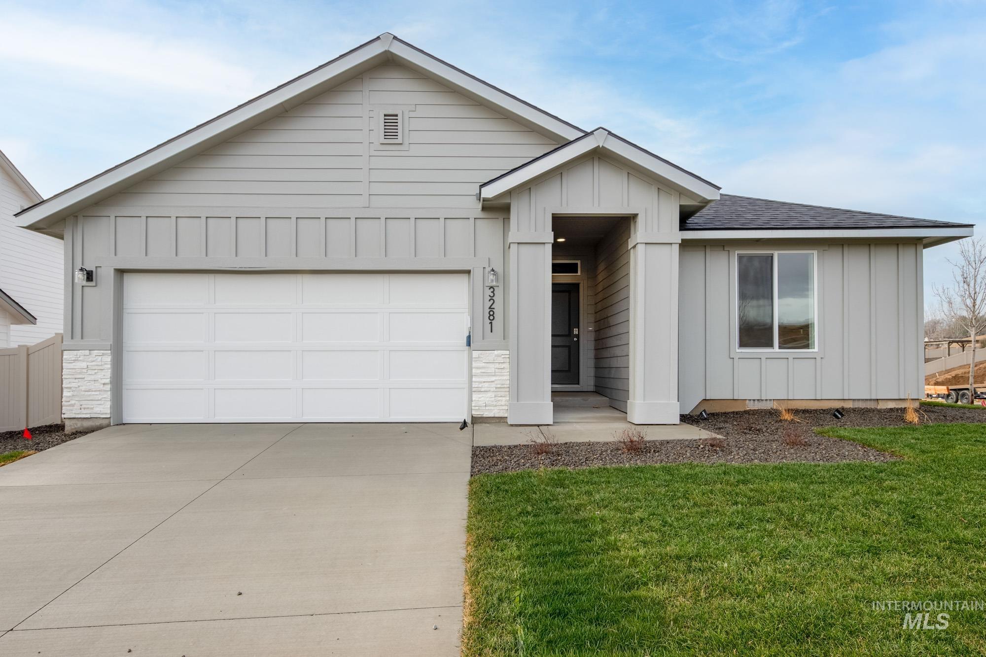 Ranch-style house with board and batten siding, driveway, roof with shingles, and a front lawn