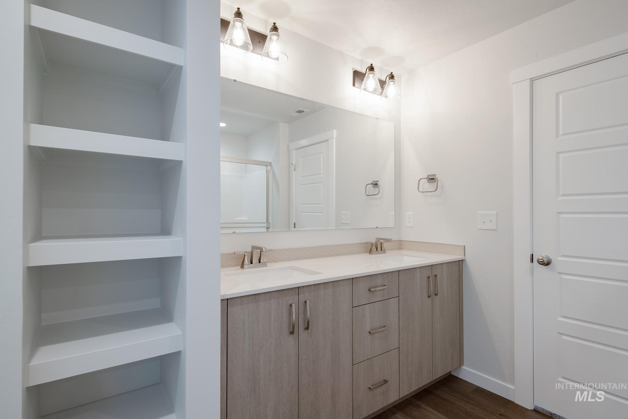 3281 North Waterbrook Way Star, ID 83669 - Photo 21 of 21 Full bath featuring double vanity, dark wood-style floors, a shower stall, and built in shelves