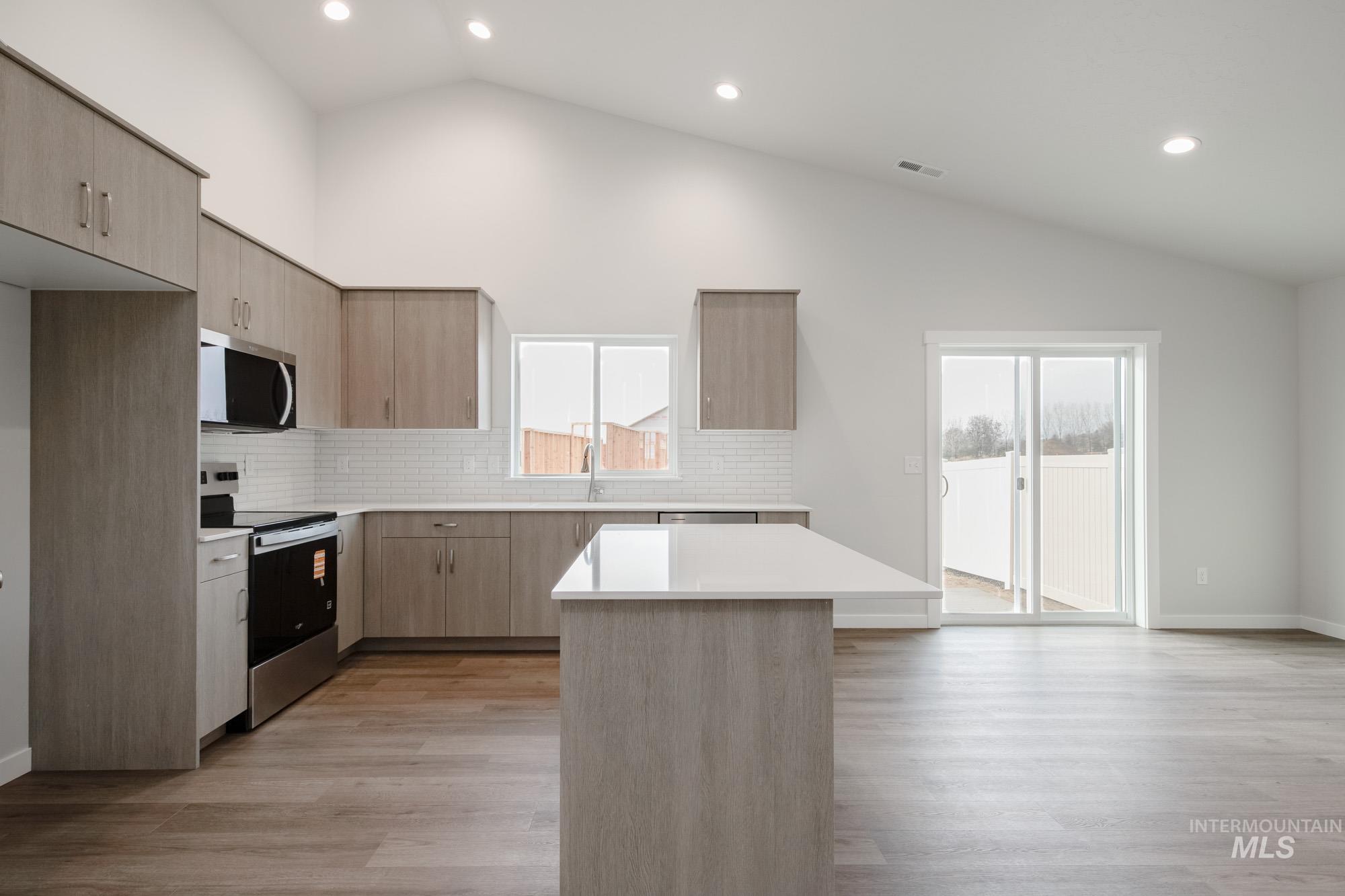 3281 North Waterbrook Way Star, ID 83669 - Photo 4 of 21 Kitchen featuring appliances with stainless steel finishes, light brown cabinets, modern cabinets, recessed lighting, and backsplash