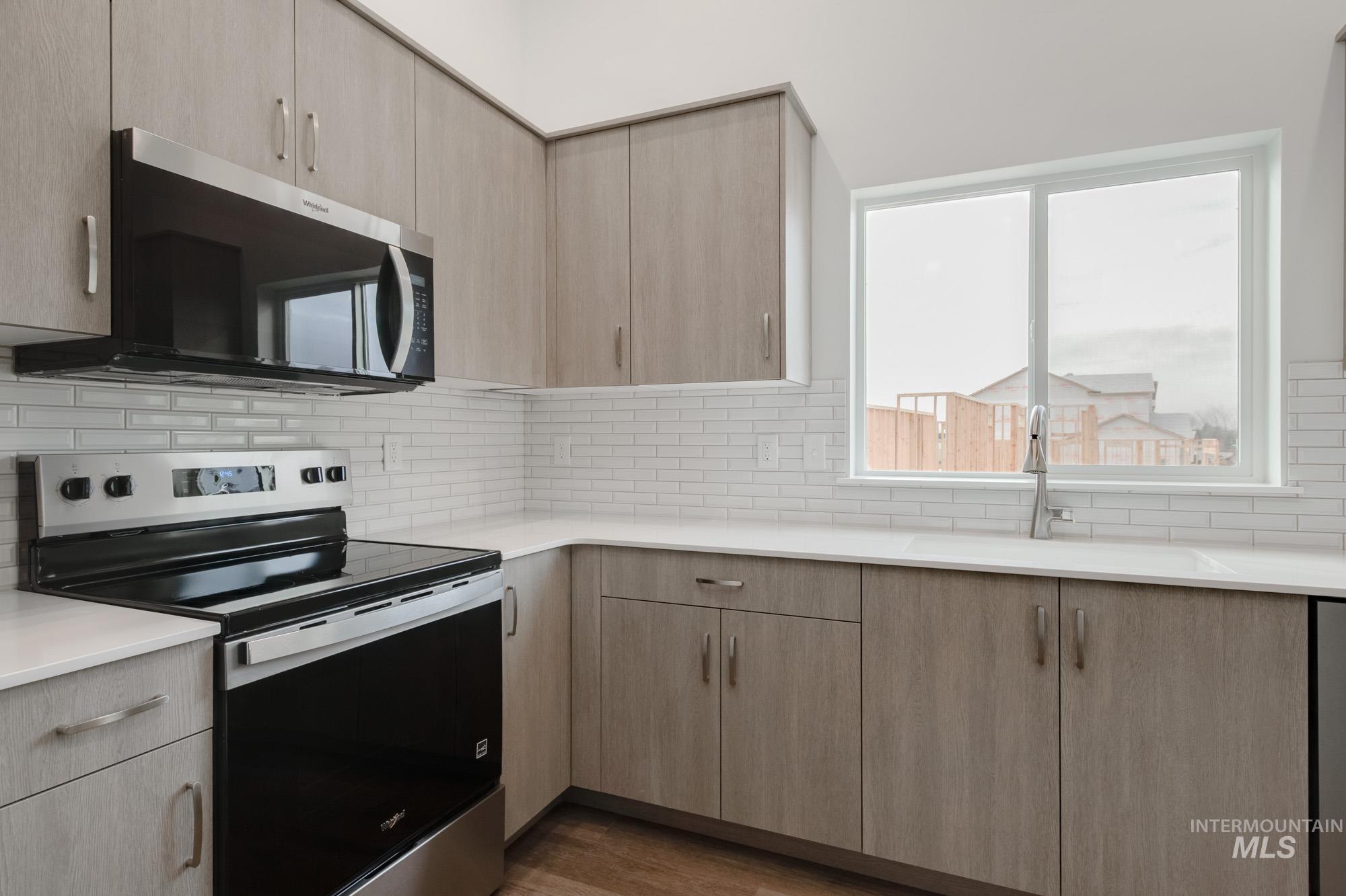 3281 North Waterbrook Way Star, ID 83669 - Photo 6 of 21 Kitchen featuring appliances with stainless steel finishes, light brown cabinets, and backsplash