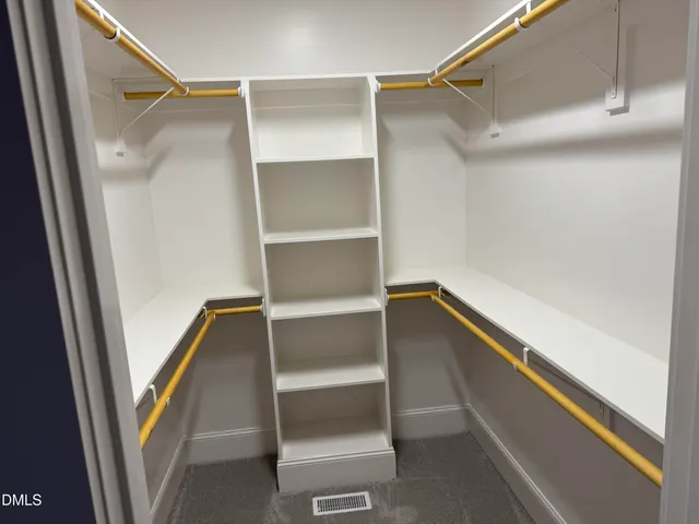 a view of walk in closet with empty racks