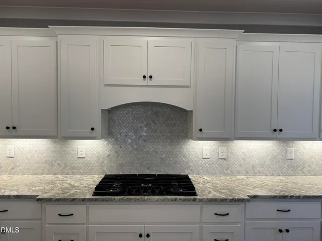 a kitchen with white cabinets and a stove