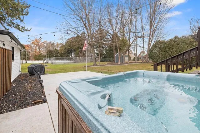 a view of a swimming pool with a patio and a yard