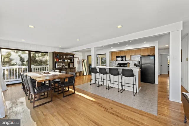 a kitchen with stainless steel appliances kitchen island granite countertop a stove a table and chairs