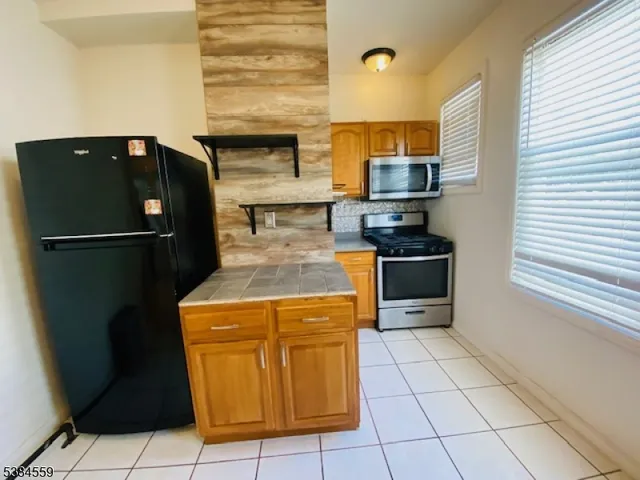 a kitchen with stainless steel appliances granite countertop a refrigerator and a stove