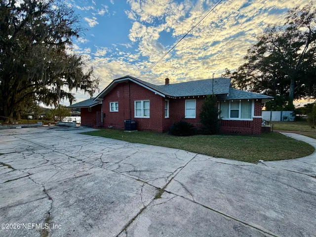 a front view of a house with a yard and trees