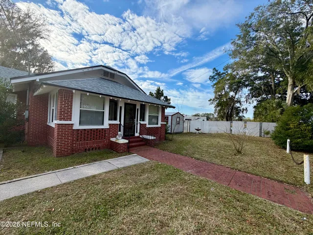 a view of a yard in front of a house with large tree