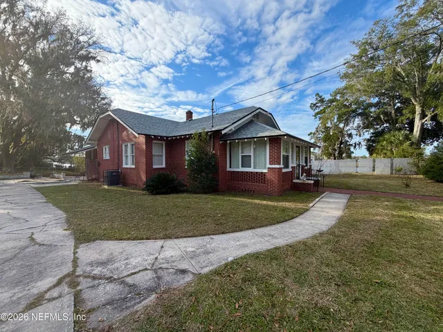 a front view of a house with a yard and trees