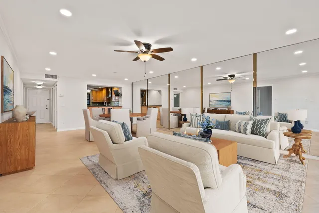 a living room with furniture and a view of kitchen