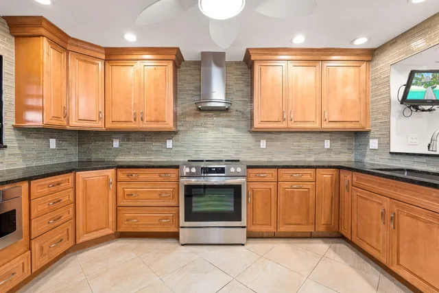 a kitchen with stainless steel appliances granite countertop a stove a sink and a microwave
