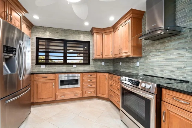 a kitchen with stainless steel appliances granite countertop a stove and a refrigerator