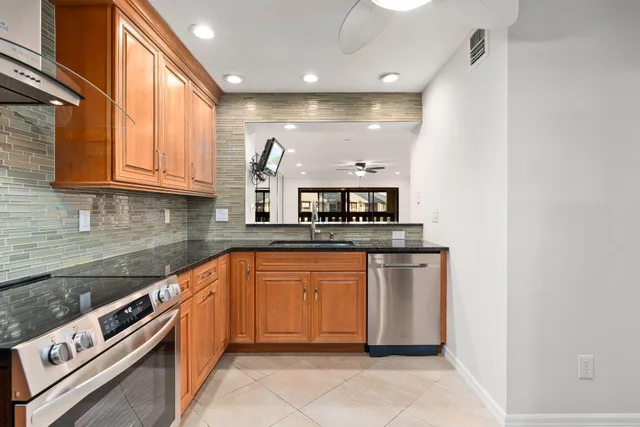 a kitchen with stainless steel appliances granite countertop a sink and a stove