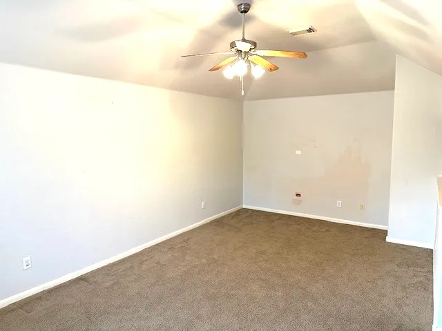 an empty room with a chandelier fan