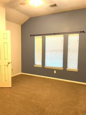a view of a room with a ceiling fan and window