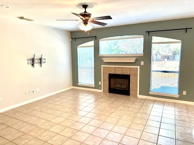 a view of an empty room with a fireplace and a window