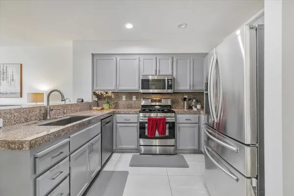 a kitchen with a refrigerator sink and cabinets