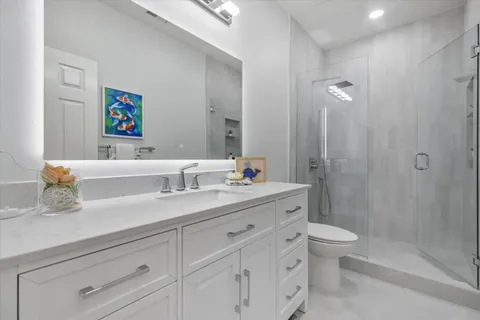 a bathroom with a granite countertop sink a toilet and a bathtub